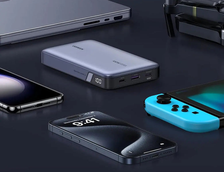UGREEN power bank on a desk with a phone and game console