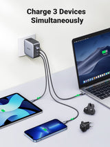 UGREEN 65W charger charging a laptop, tablet and phone at the same time